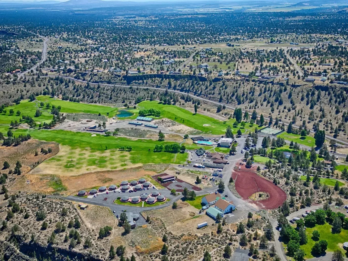 Aerial view of Crooked River Ranch community, Terrebonne Oregon — pool, high desert landscape and canyon views