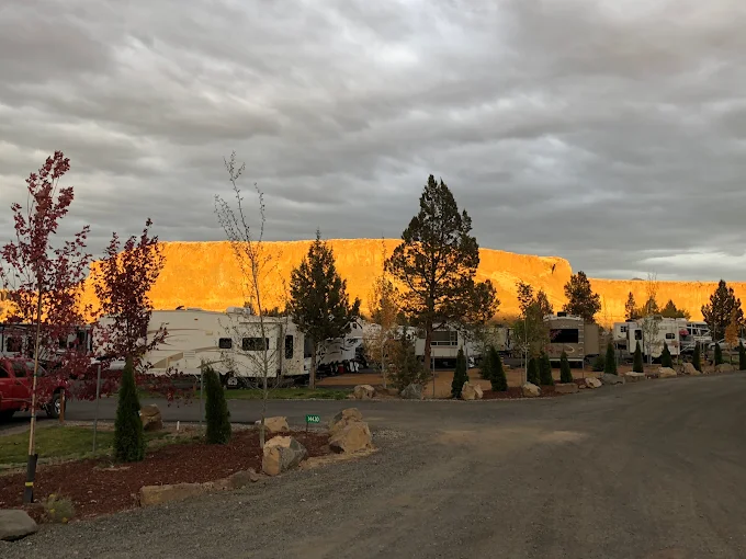 Copper Ridge RV Park entrance with RVs parked and canyon rimrock glowing orange at dusk, Terrebonne Oregon