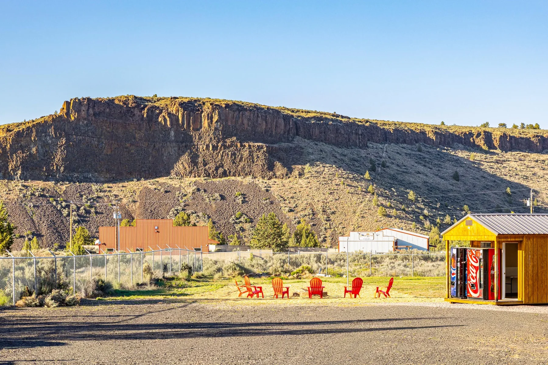 Community seating area with red Adirondack chairs and canyon rimrock, Copper Ridge RV Resort